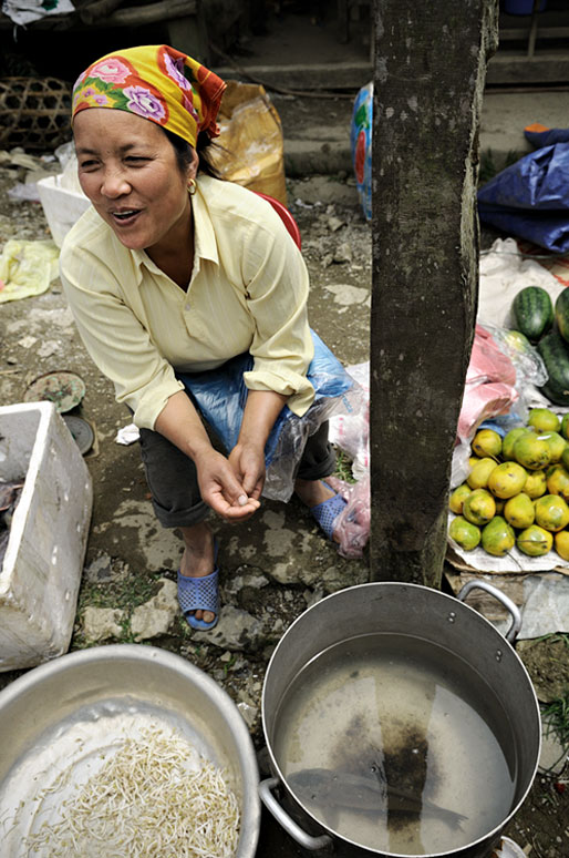 Femme assise qui rigole au marché de Quyet Tien, Vietnam