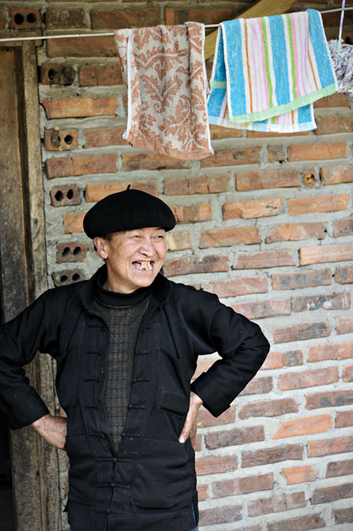 Femme au sourire édenté devant sa maison, Vietnam