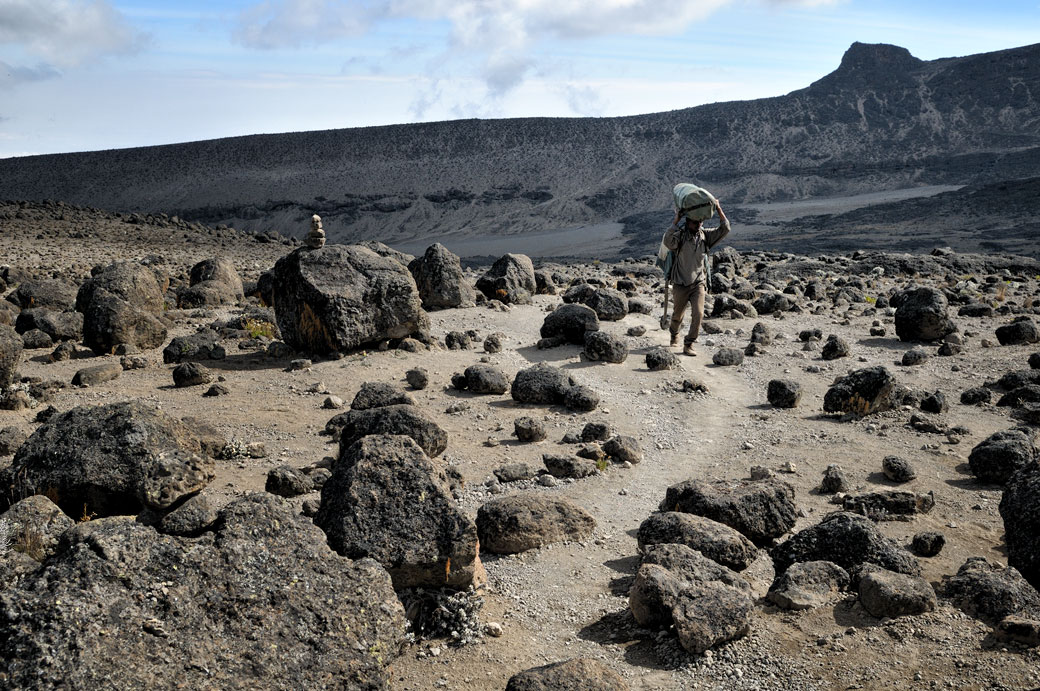 Porteur et pierres volcaniques sur le Kilimandjaro, Tanzanie