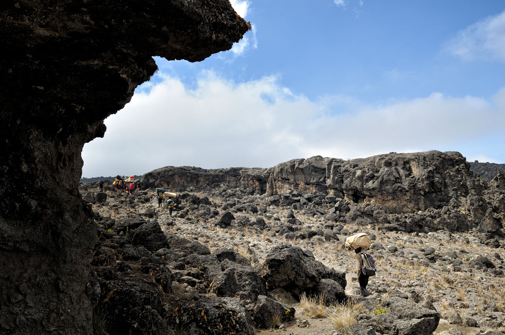 Porteurs dans un paysage volcanique sur le Kilimandjaro, Tanzanie