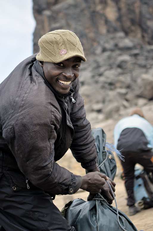 Porteur souriant au camp de Lava Tower qui prépare son sac, Tanzanie