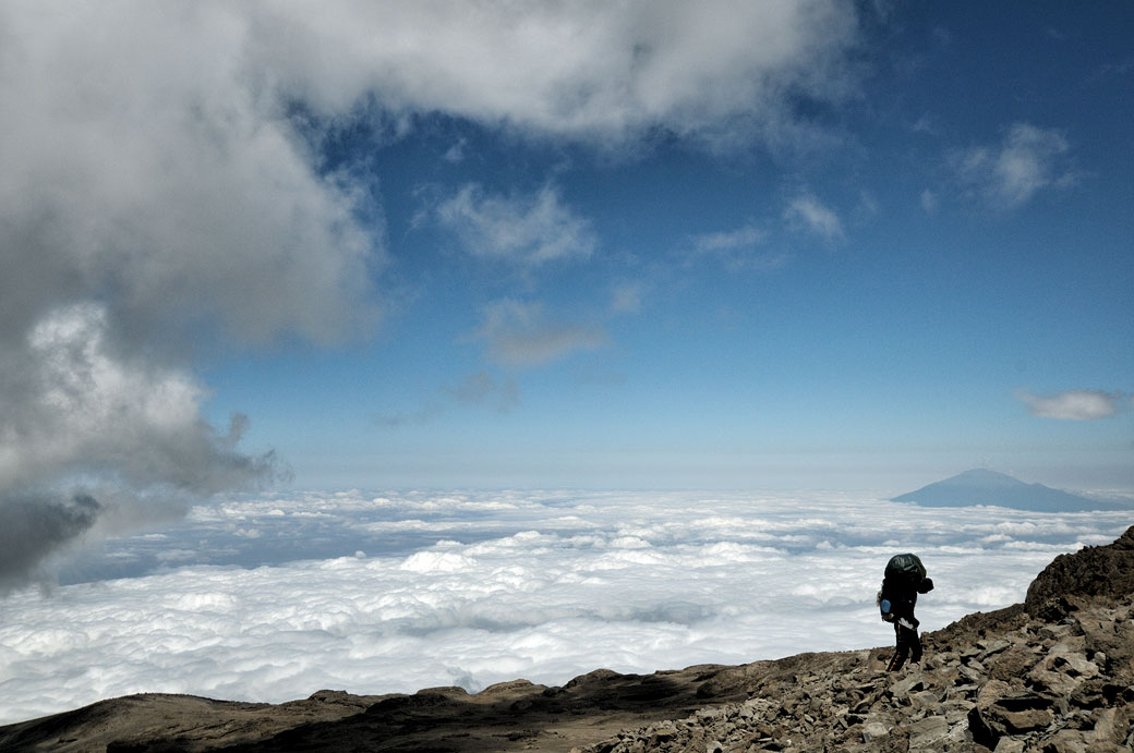 Porteur et nuages avec le mont Méru depuis le camp Barafu du Kilimandjaro