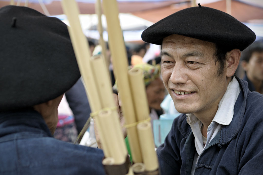 Hommes portant des bérets basques qui discutent au marché de Meo Vac, Vietnam