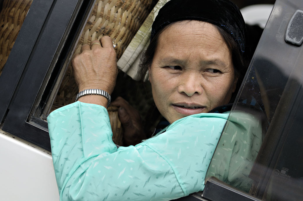 Femme qui regarde par la fenêtre d'un bus au marché de Meo Vac