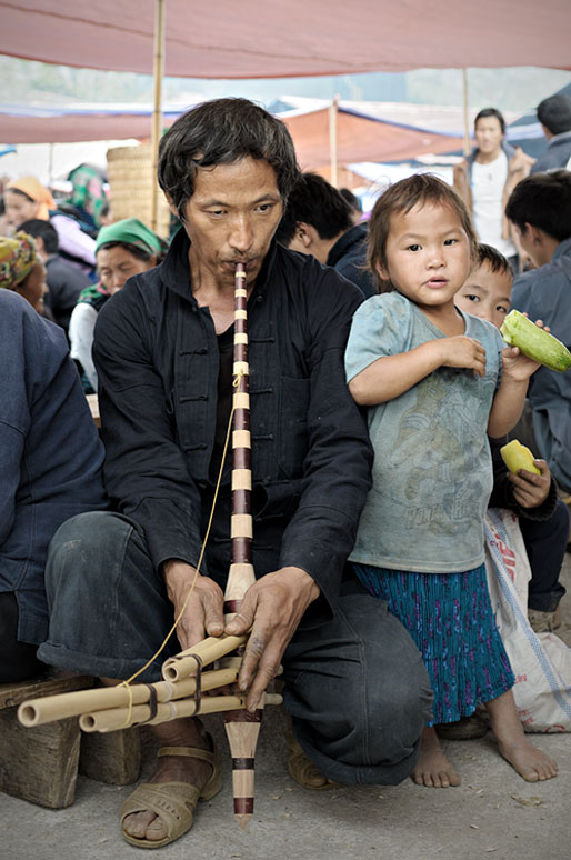 Homme qui joue d'un instrument de musique au marché de Meo Vac