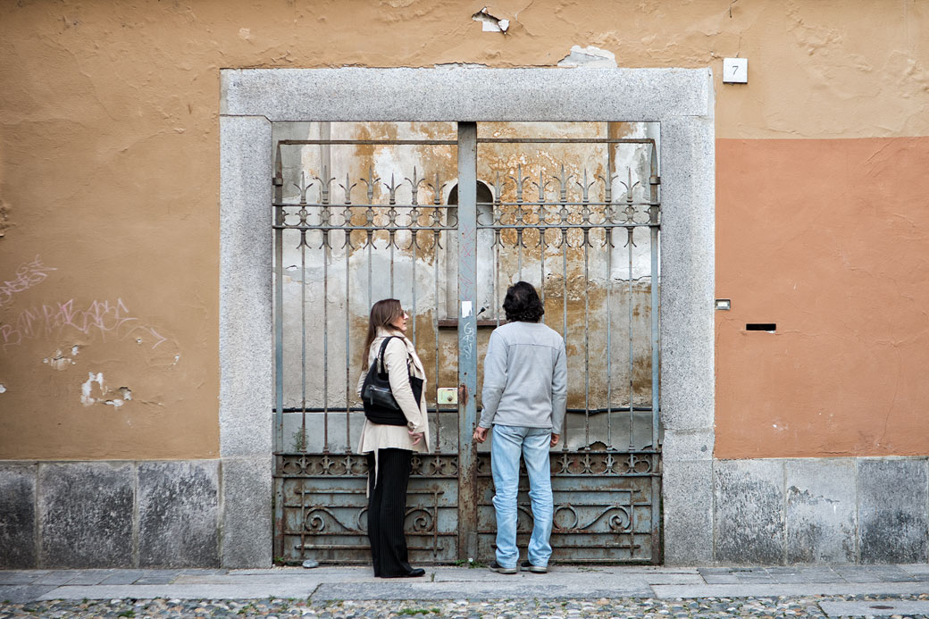 Couple devant un portail de fer à Pavie, Italie