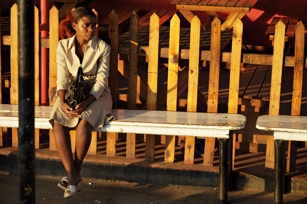 Jeune femme qui attend le bus à Livingstone, Zambie