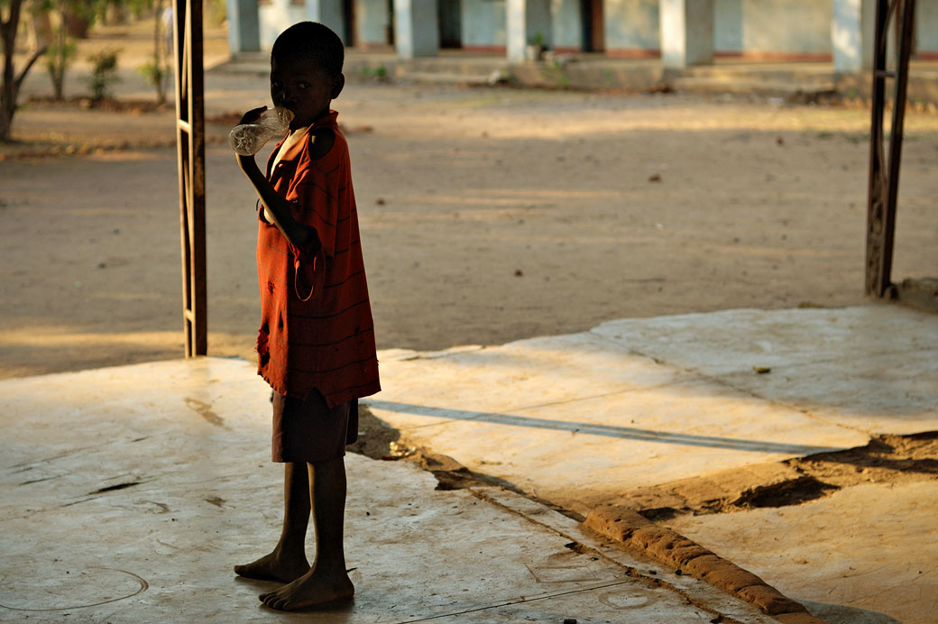 Garçon avec une bouteille en plastique au village de Kawaza, Zambie