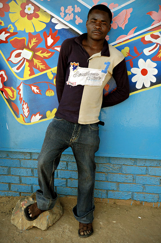 Homme debout devant un mur bleu à Lusaka, Zambie