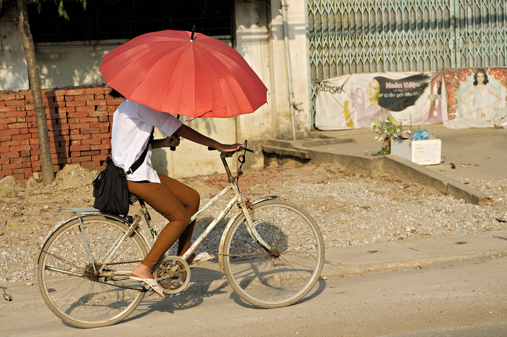 Jeune femme sur un vélo avec une ombrelle, Vietnam