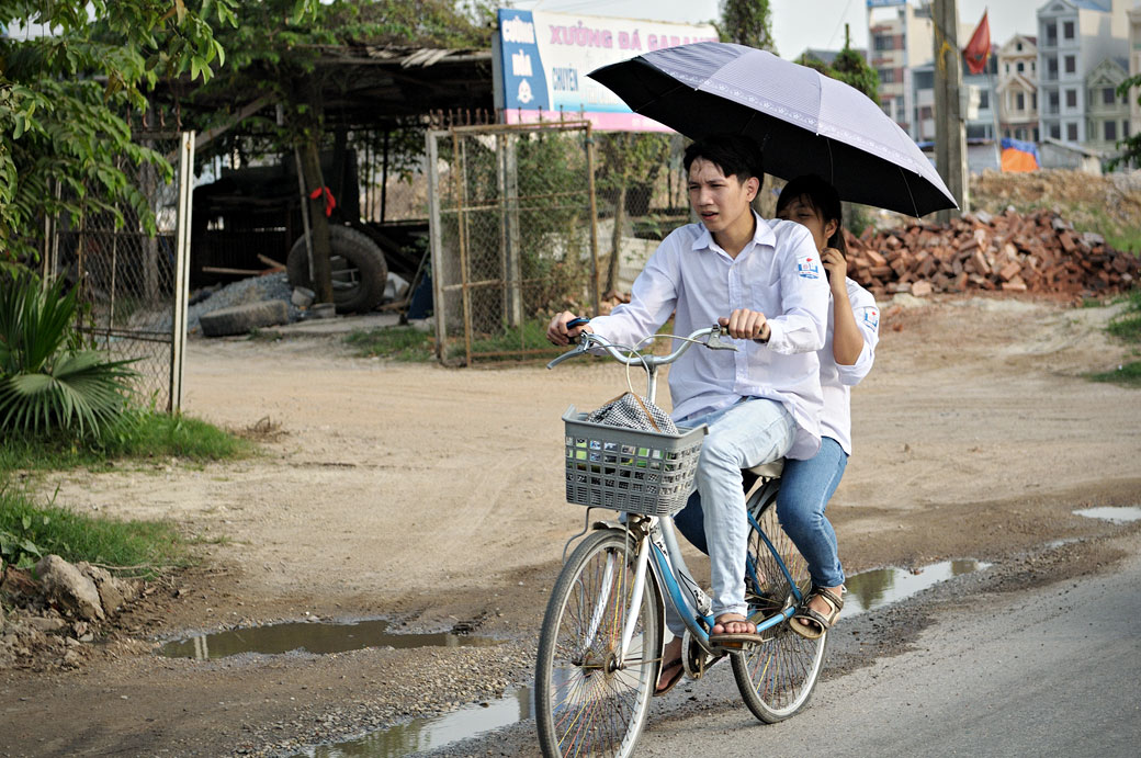 Deux étudiants sur un vélo avec une ombrelle, Vietnam