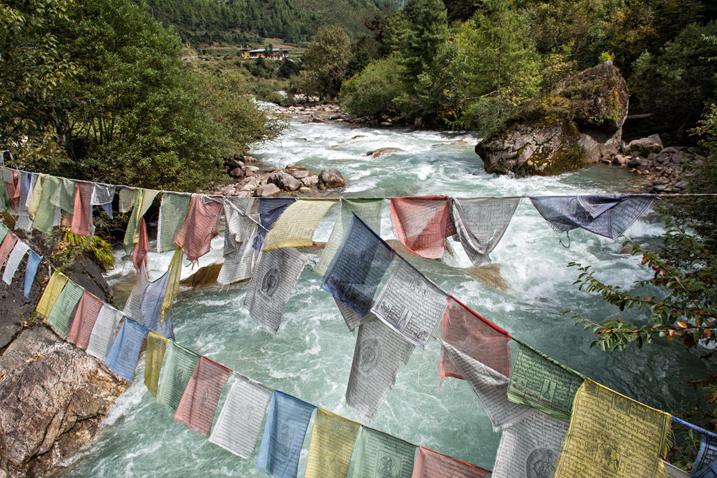 Drapeaux de prières au-dessus d'une rivière à Shana, Bhoutan