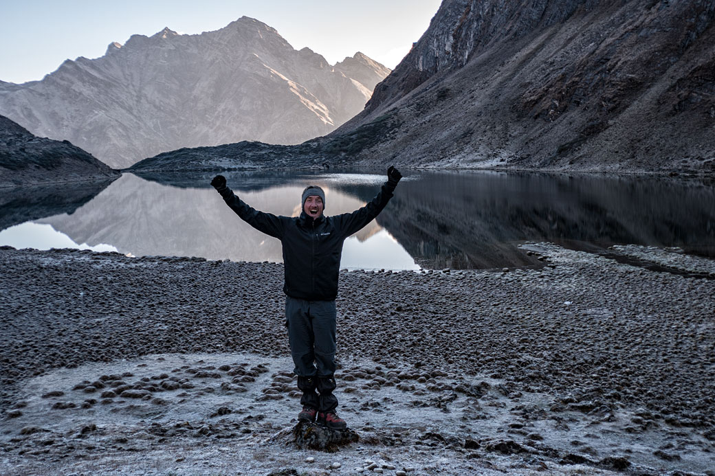 Trekkeur heureux devant un lac de montagne