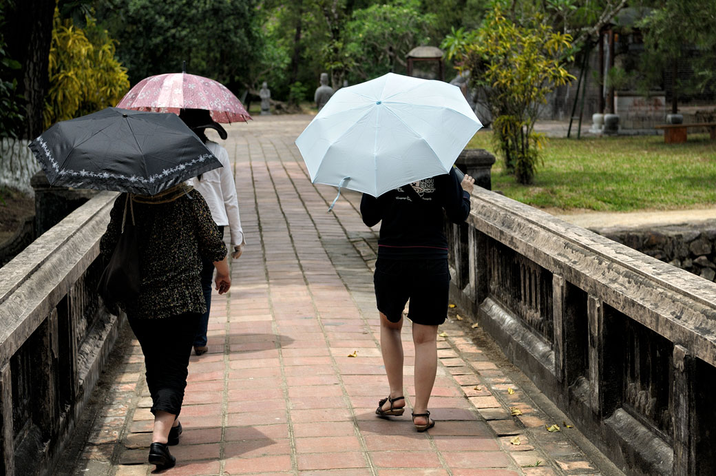 Touristes avec des ombrelles au tombeau de Minh Mang, Vietnam