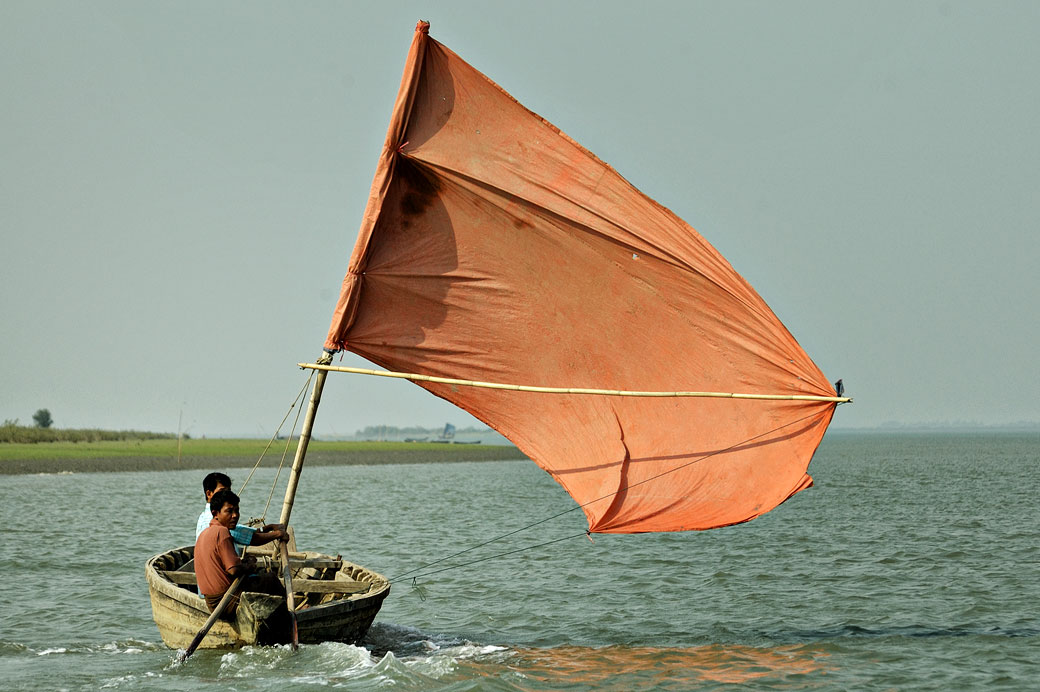 Bateau à voile orange sur le fleuve Kaladan à Sittwe, Birmanie
