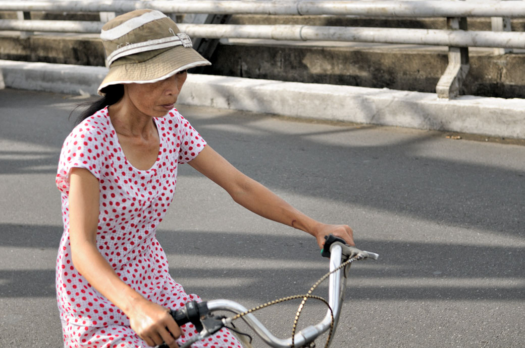 Femme à vélo sur le pont Trang Tien à Hué, Vietnam