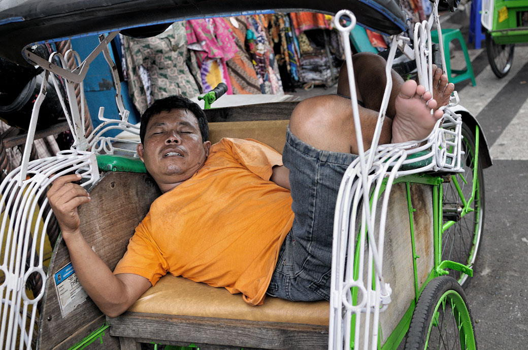 Homme qui fait la sieste dans son cyclo-pousse à Yogyakarta, Indonésie
