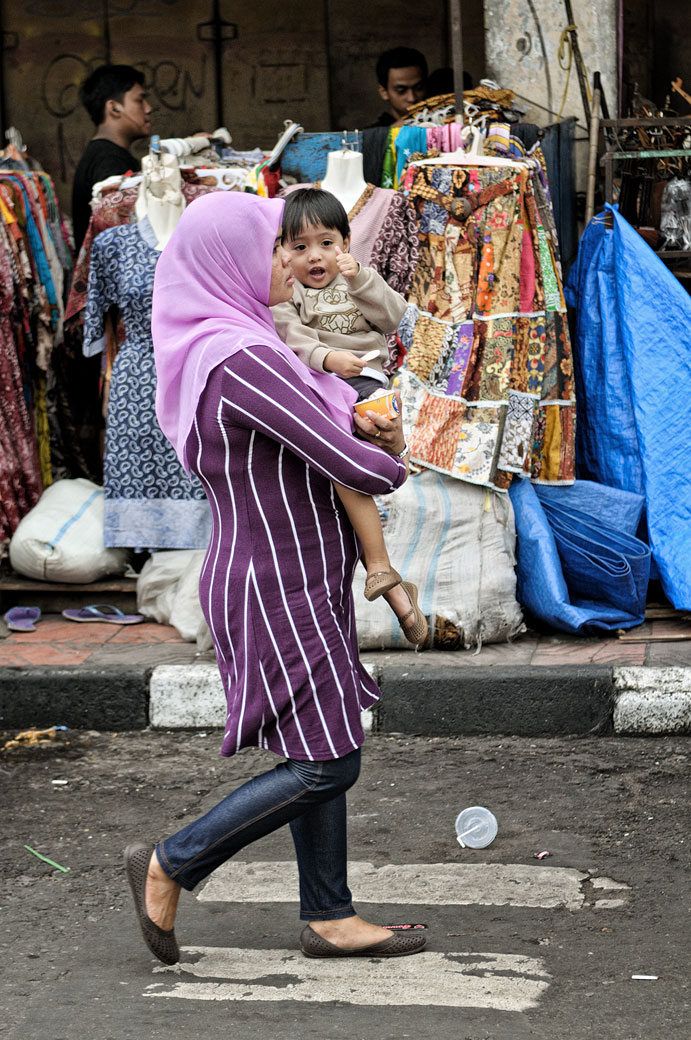Femme voilée portant son enfant dans une rue de Yogyakarta, Indonésie