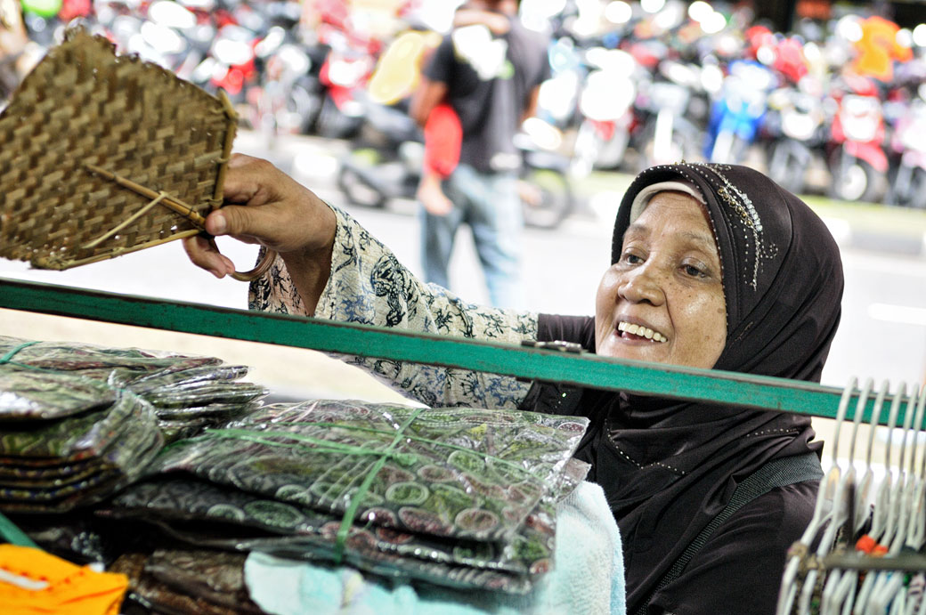 Femme qui dépoussière son shop à Yogyakarta, Indonésie