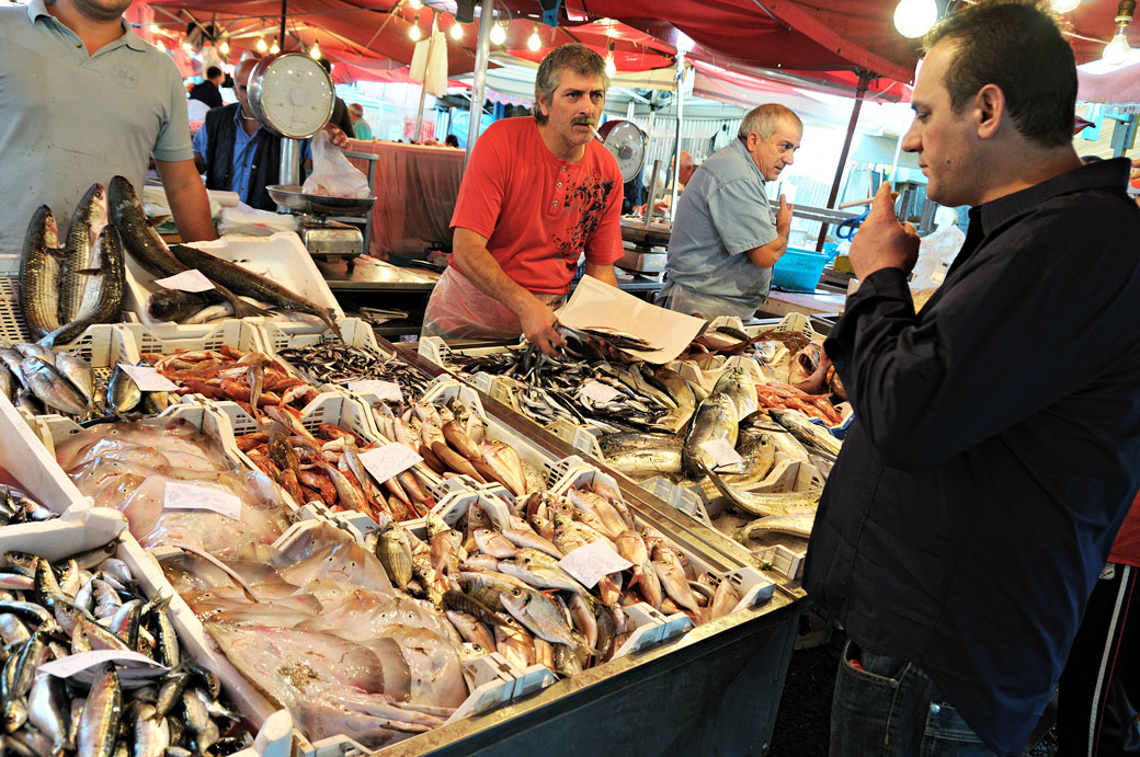 Client et poissonniers à la Pescheria de Catane en Sicile, Italie