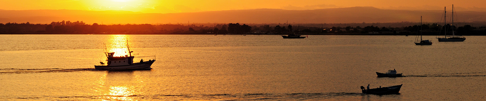Top image bateaux au coucher du soleil à Syracuse en Sicile