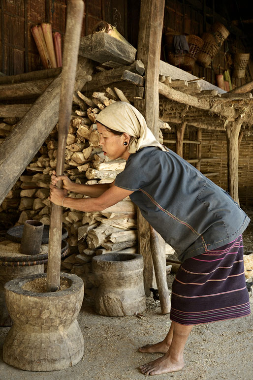 Femme Loi qui bat les graines de la récolte à Wun Nyat, Birmanie