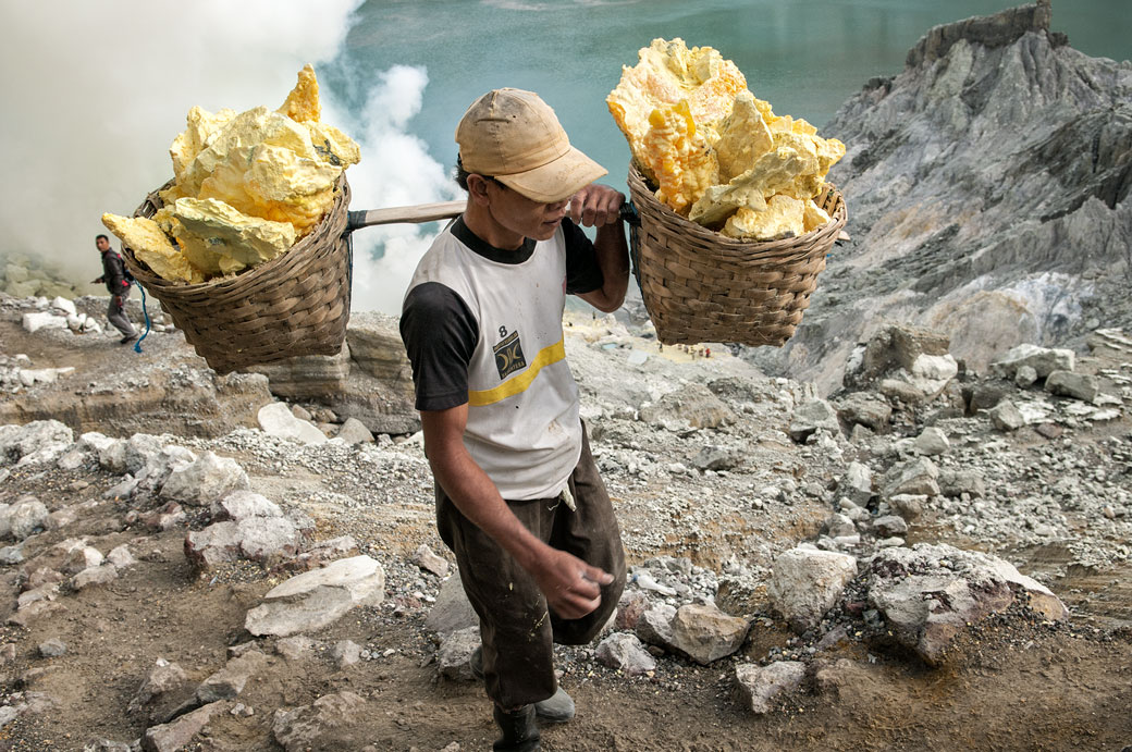 Porteur avec deux paniers remplis de soufre au Kawah Ijen, Indonésie