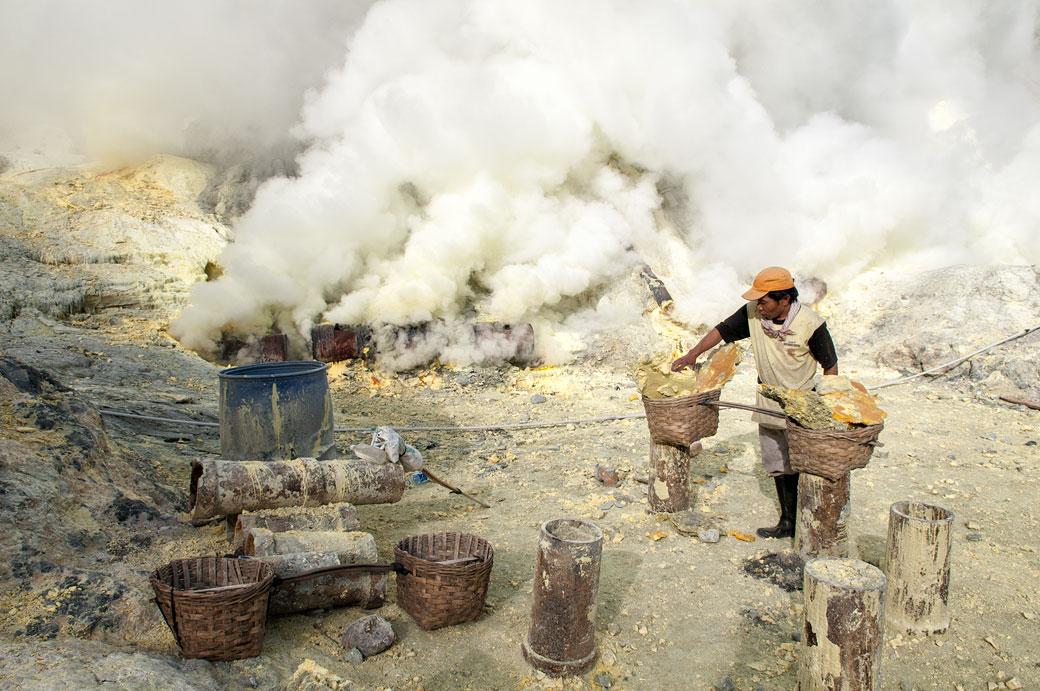 Mineur qui remplit ses paniers de soufre au Kawah Ijen, Indonésie