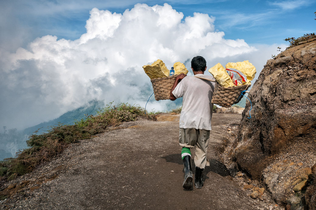 Porteur avec sa cargaison de soufre sur un sentier du Kawah Ijen, Indonésie