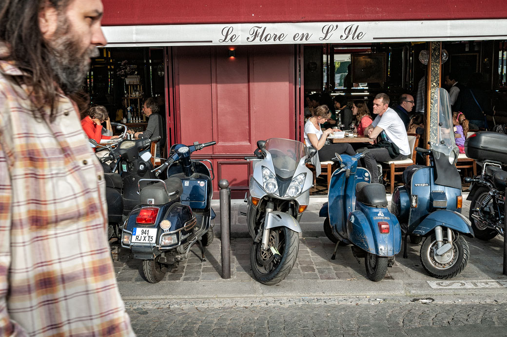 Scooters et passant devant un restaurant de l'île Saint-Louis, France