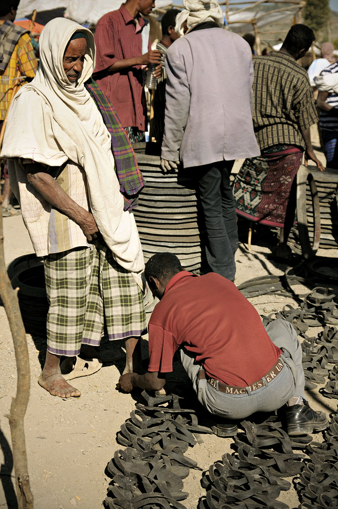 Homme qui essaie des sandales au marché de Bati, Ethiopie