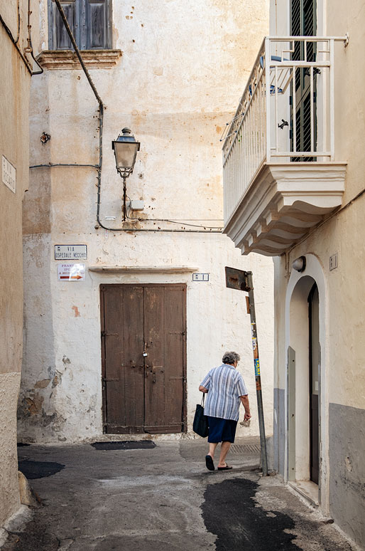Femme qui marche dans une ruelle de Gallipoli, les Pouilles