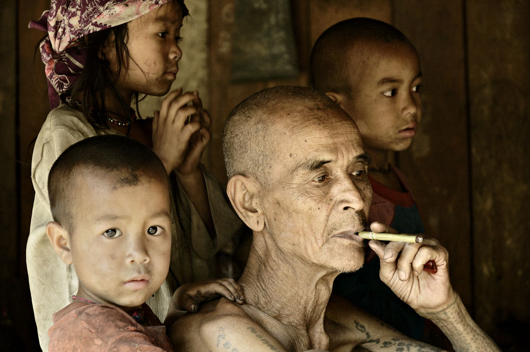 Vieil homme qui fume entouré d'enfants à Wun Nyat, Birmanie