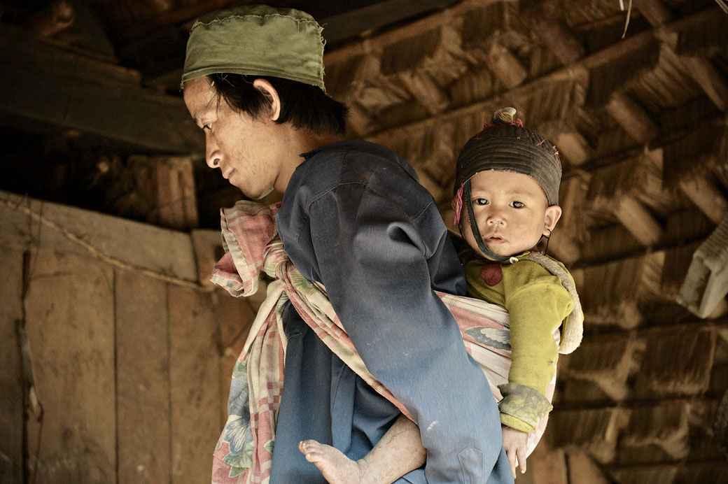 Homme Loi avec son bébé dans une maison à Wun Nyat, Birmanie