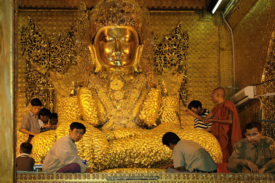 Fidèles au pied du bouddha en or de Mahamuni à Mandalay, Birmanie