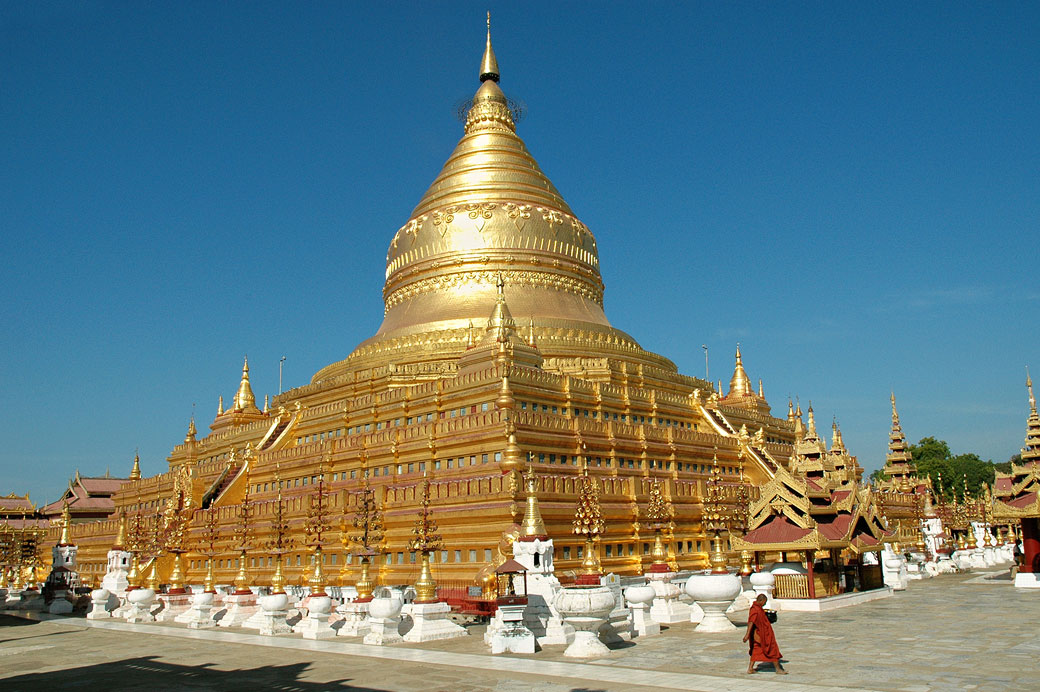 Un moine passe devant la pagode Shwezigon de Bagan, Birmanie