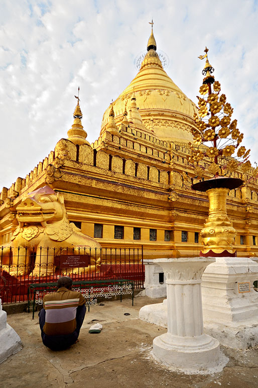 Un homme médite devant la pagode Shwezigon de Bagan, Birmanie