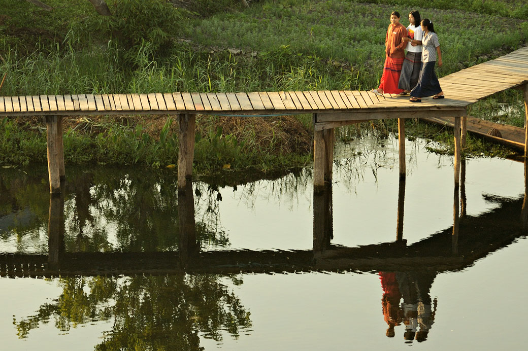 Réflexion de trois copines sur une passerelle sur le lac Inle