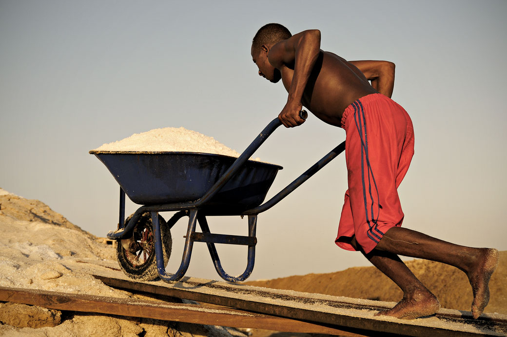 Homme avec sa brouette remplie de sel dans les salines d'Afdera