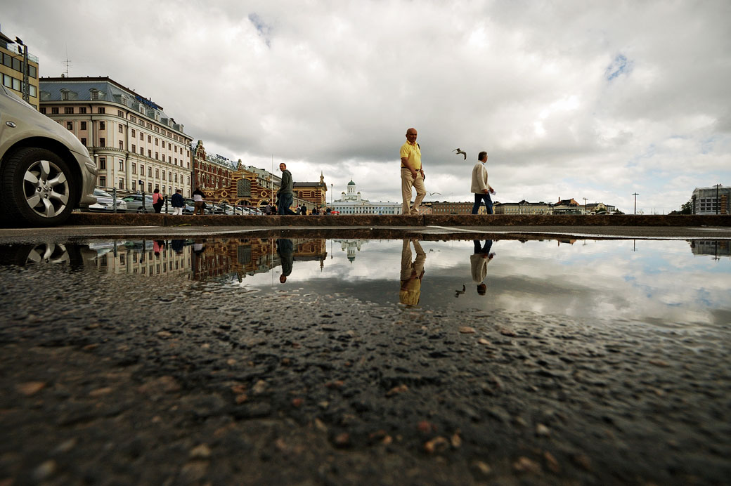 Reflet de passants dans une flaque d'eau à Helsinki, Finlande