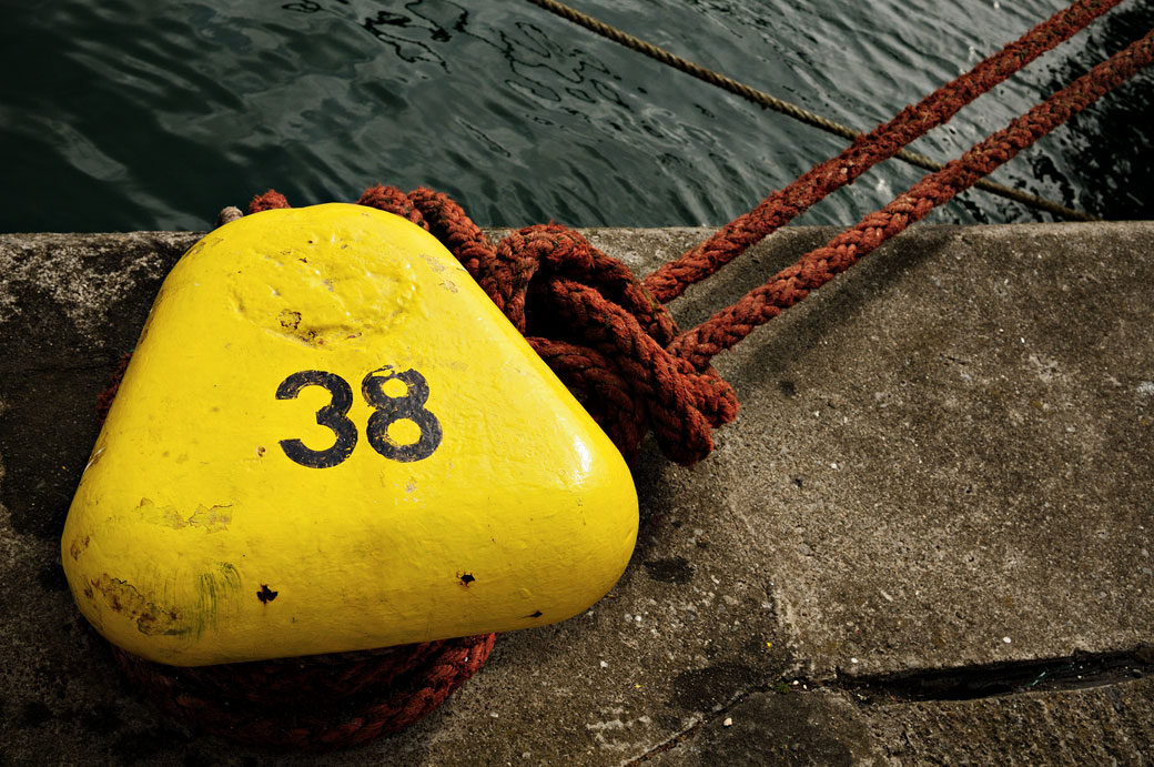 Corde accrochée à un bollard jaune dans le port de Howth