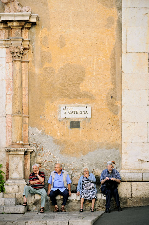 Personnes assises devant l'église Sainte Catherine à Taormine en Sicile