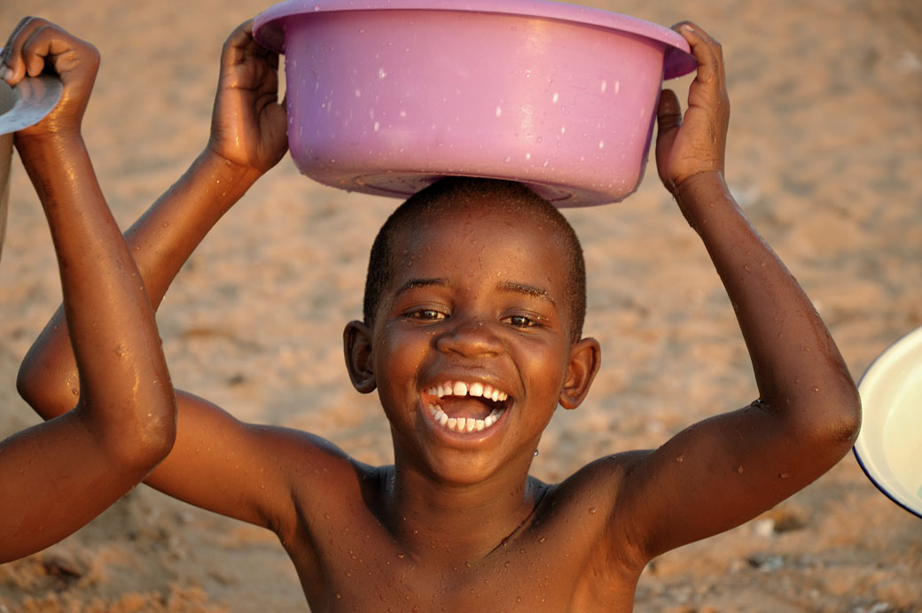 Enfant souriant avec une bassine sur la tête, Malawi