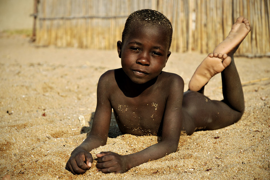 Garçon relax sur la plage de Cape Maclear, Malawi