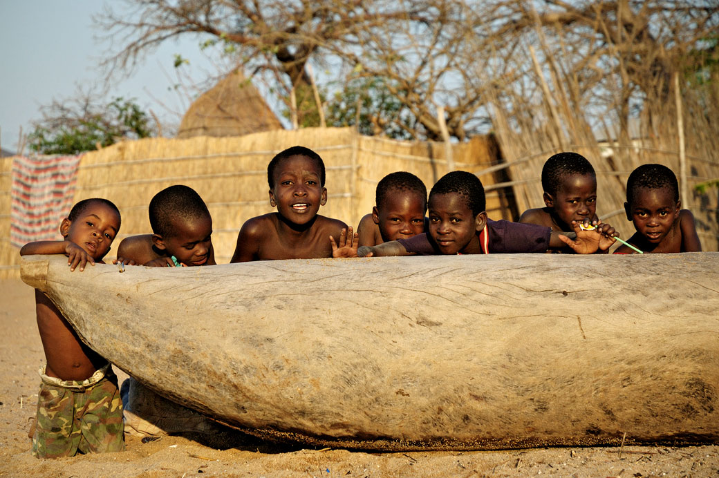 Groupe d'enfants derrière une pirogue à Cape Maclear, Malawi