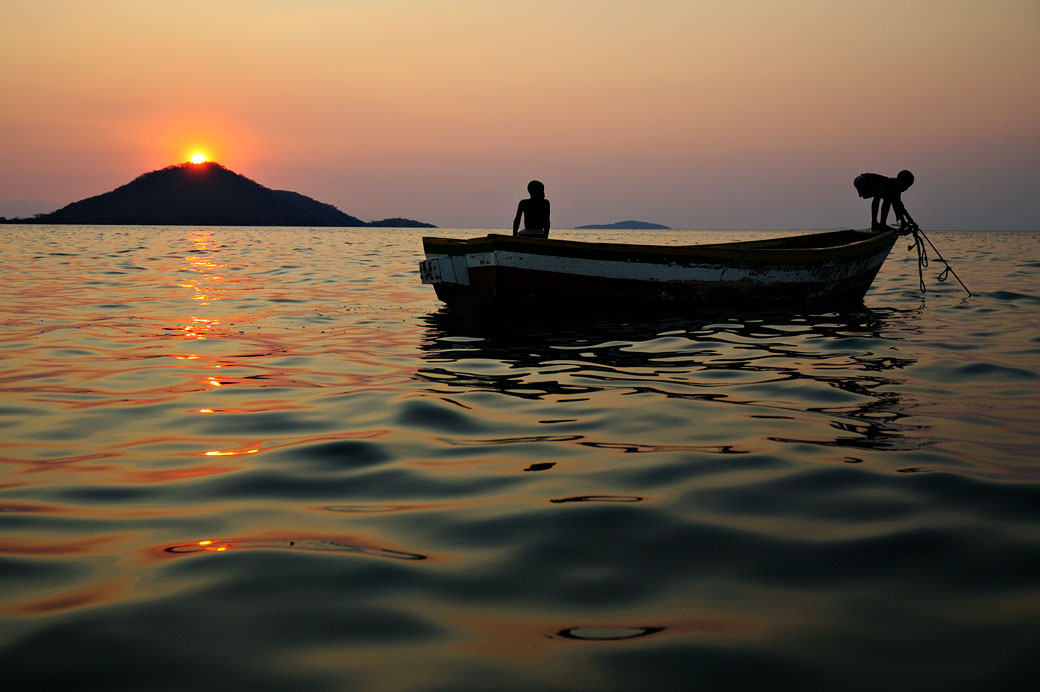 Enfants sur un bateau à Cape Maclear au coucher du soleil, Malawi