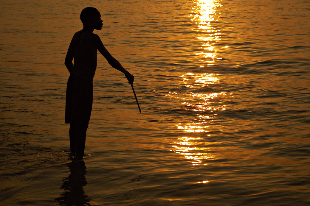 Silhouette d'un pêcheur au coucher du soleil au lac Malawi