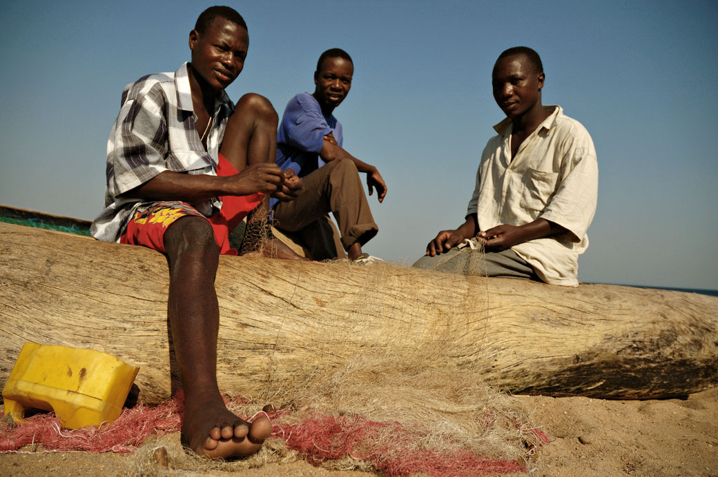 Trois pêcheurs sur une pirogue sur la plage de Cape Maclear, Malawi