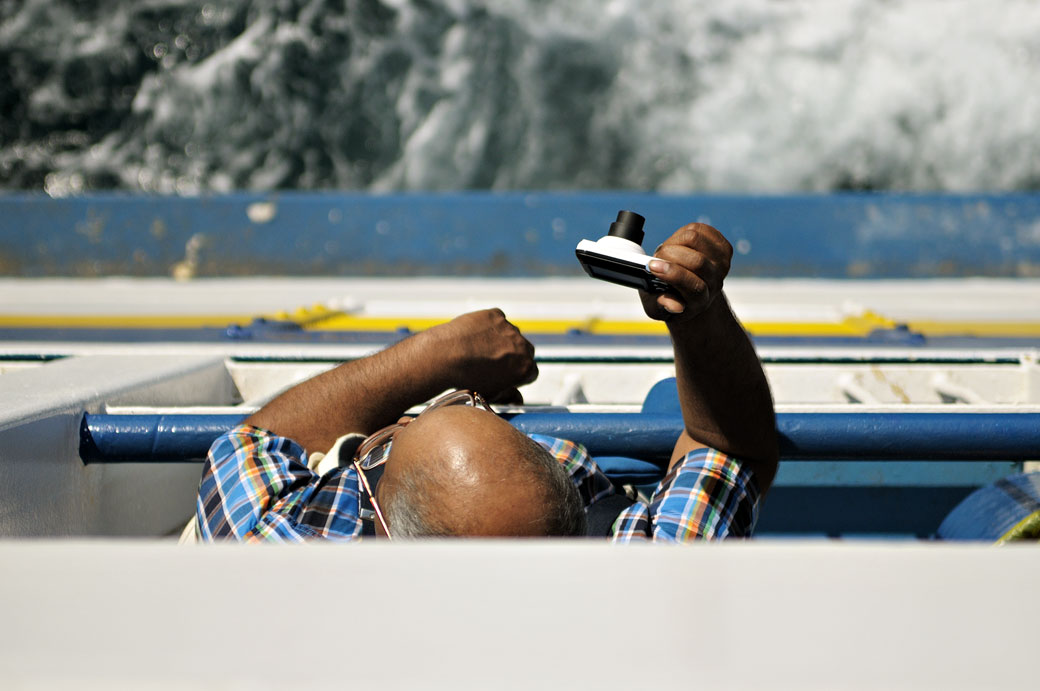 Homme qui prend une photo sur le ferry pour Gozo