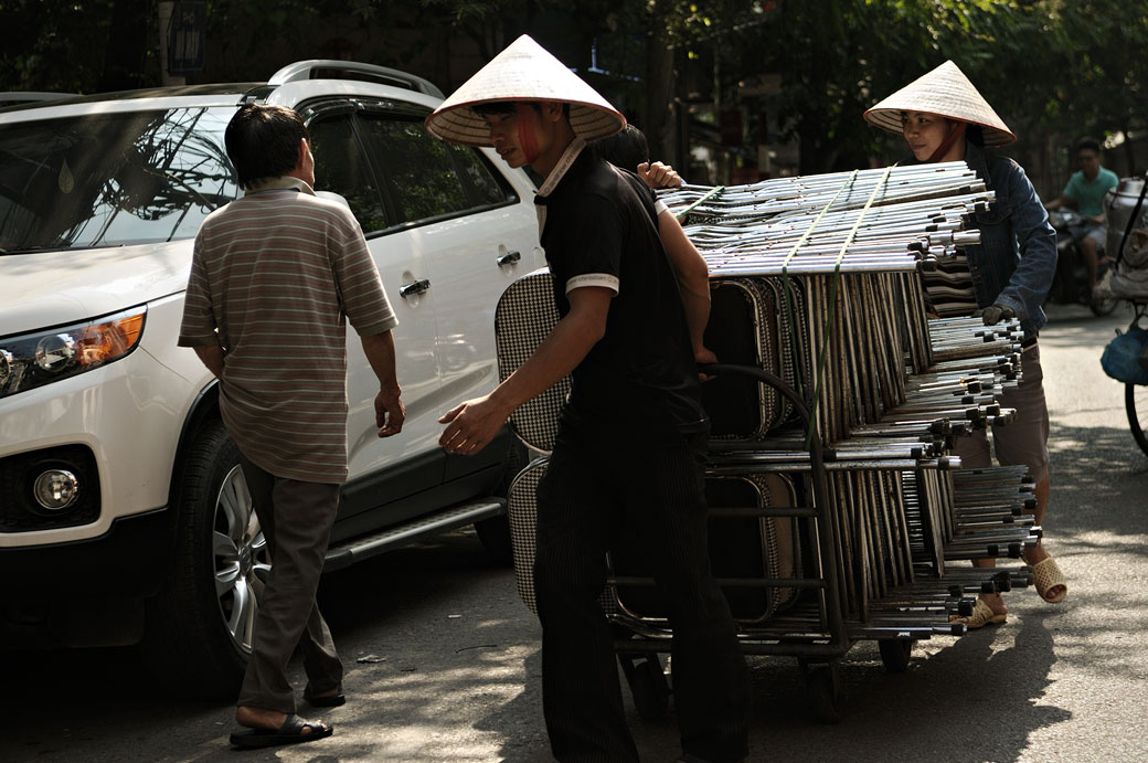 Transporteurs de chaises dans une rue de Hanoi, Vietnam